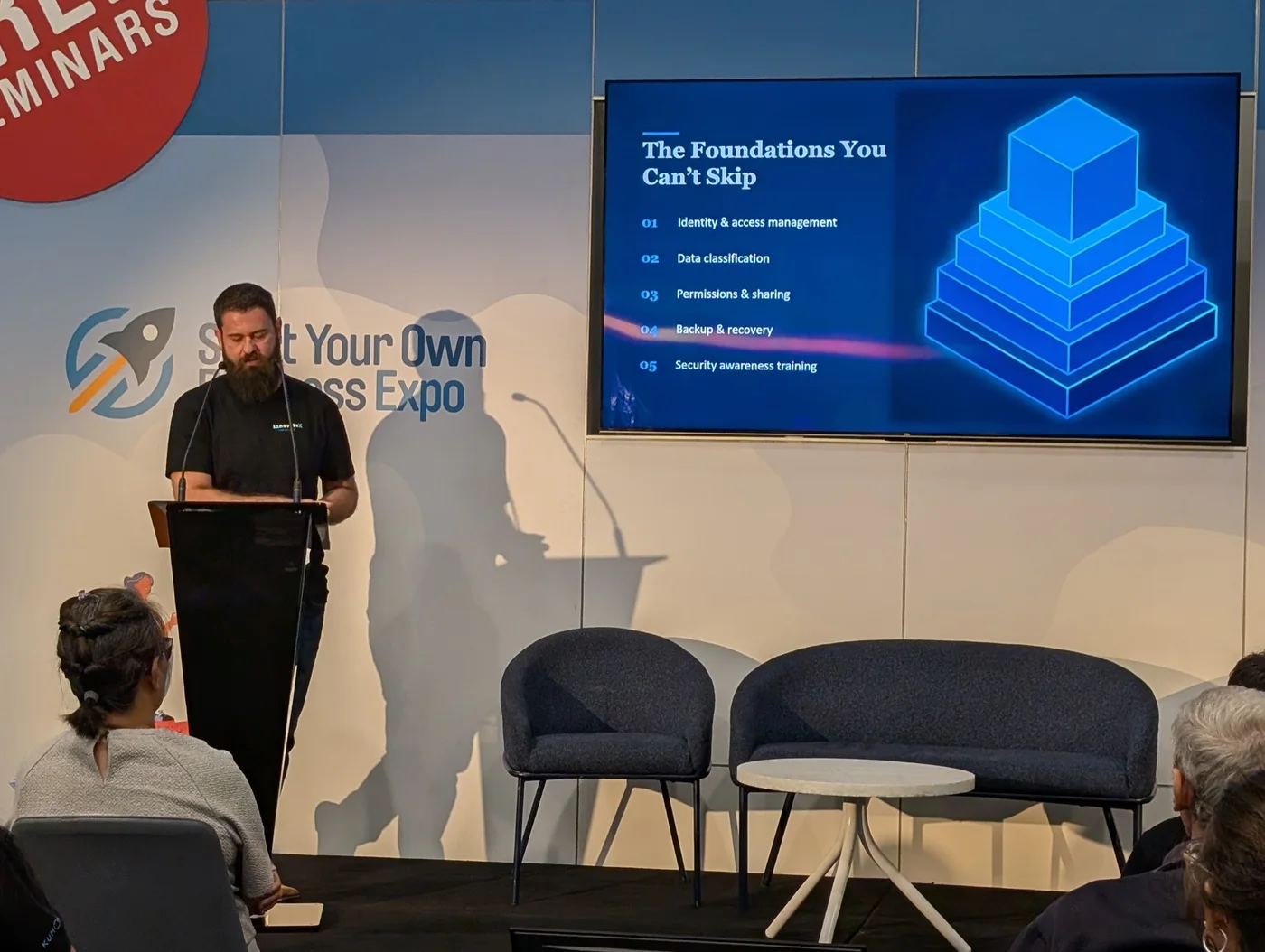 Todd presenting AI Ready from Day One at the Start a New Business Expo, with the audience and presentation screen in view